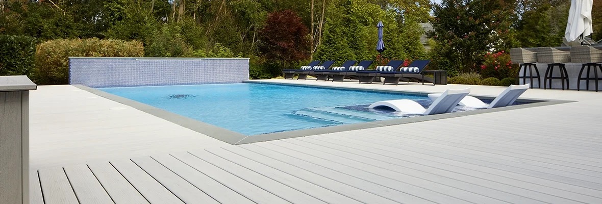 In-ground pool with fountain wall and loungers